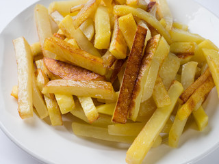 Appetizing fried potatoes on a white plate. Close-up