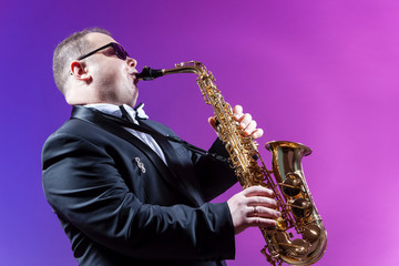 Music and Musicians Concepts. Portrait of Mature Expressive Caucasian Saxophonist Against Colorful...