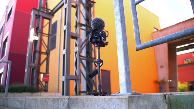A steadycam with a Camera / DSLM  setup with microphone mounted on it.