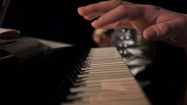 Fingers of pianist pressing at synthesizer keys. Stock. Hands of man playing solo of music at piano. Slow motion Top view Close up