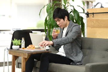 PCを見ながら飲む男性