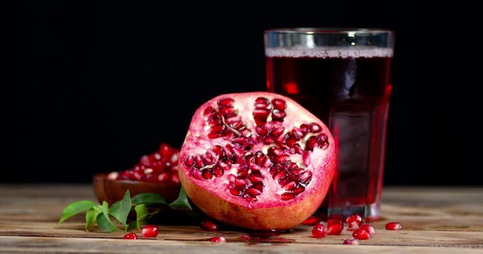 A glass of juice from fresh pomegranate rotates slowly.