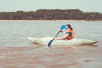 Naklejka premium Athletic girl is kayaking.