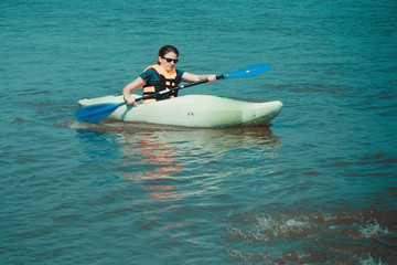 Girl with a paddle on a kayak.