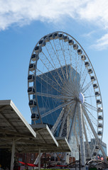 A white wheel of fortune in front of the blue sky with a few clouds