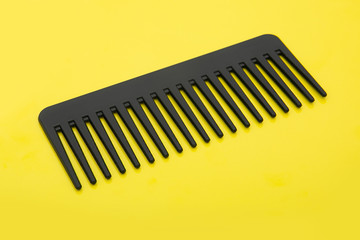black hairbrush isolated on a yellow background