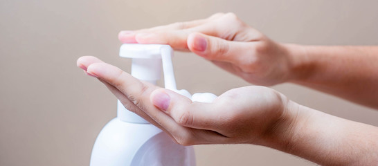 Woman using foaming hand soap in home or office, against coronavirus or Corona Virus Disease (Covid-19) . Antiseptic, personal Hygiene and Health concept