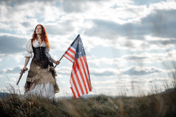 Girl in historical dress of 18th century with flag of United States. July 4 is US Independence Day....