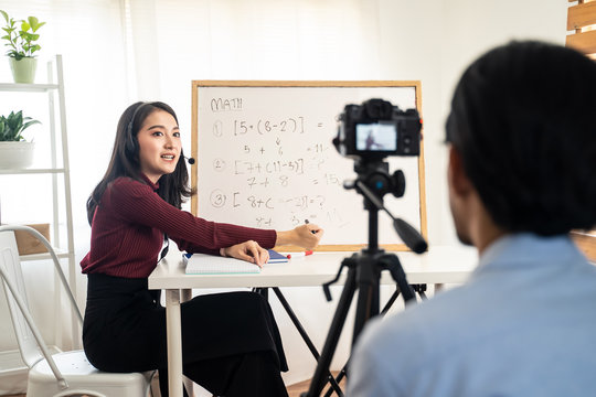 Asian School Woman Teacher Working From Home Teaching Online Internet Class To Student Studying From Home. Man Using Camera To Record Girl Digital Live. Remote Education Class During Covid19 Pandemic.