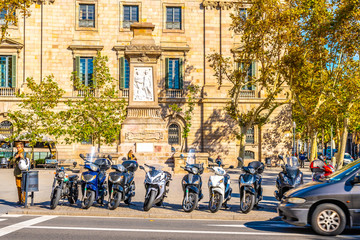 Obraz premium Barcelona, Spain. City street view of Medieval style brick building in Catalonia, with Antoni Lopez Y Lopez monument in front and a row of bikes parked on sidewalk outside.