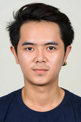 Naklejka premium Portrait of young Asian man looking at camera