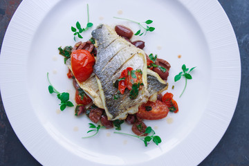 Dorado with vegetables, Raw fish on a dark background