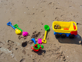 Fototapeta na wymiar Colorful children's beach toys on sand background.