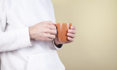 Man holding cup of coffee on yellow background.