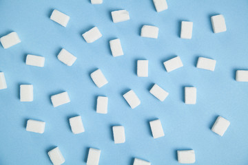 Fototapeta na wymiar Sugar cubes on the blue background.