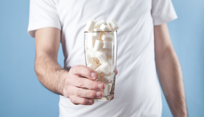 Man holding a glass with a sugar cubes.