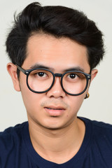 Portrait of young Asian nerd man with eyeglasses