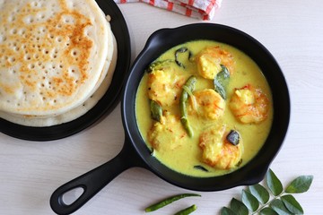 Yellow Prawns or Shrimp curry served with Amboli or Soft Dosa. Prawns cooked in coconut milk with mild spices. Prawns yellow Thai Curry. Goan fish Curry. Ingredients background with copy space. 