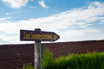 Obraz premium wooden sign and green grass on blue sky