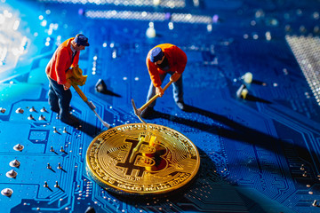 Bitcoin mining miniature worker, small figure holding mattock digging on shiny golden Bitcoin...
