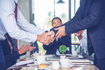 Team Business Partners shaking hands together to Greeting Start up new project. Shakehand Teamwork Partnership outside office modern city background. Businessman handshake together.  Business concept