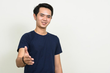 Portrait of happy young Asian man giving handshake