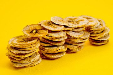 Dried banana chips, sliced in thin circles. Background for healthy and natural nutrition.