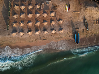 Aerial view of amazing beach with umbrellas and turquoise sea at sunrise. Black Sea at Vama Veche, Romania