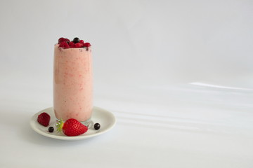 Colorful smoothie in glass with fresh fruits on white background