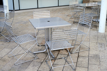 metal chairs and tables at empty outdoor cafe