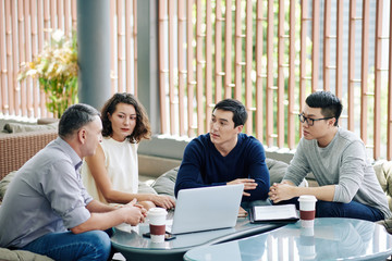 Group of serious business people discussing plan of project development in new business reality...