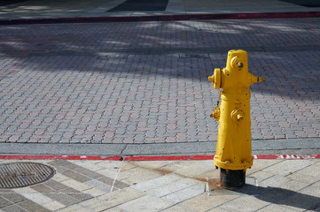 Stamped concrete street with yellow fire hydrant on sidewalk