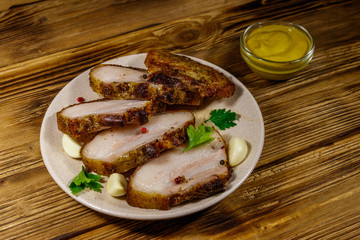 Baked pork belly in a plate on wooden table