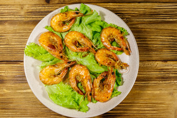 Tasty baked shrimps on a wooden table. Top view