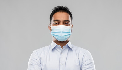 business, healthcare and people concept - portrait of indian man in shirt wearing face medical mask for protection from virus disease over grey background