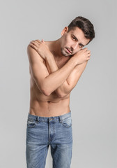 Young man with anorexia on grey background