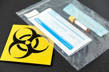 medicine, healthcare and pandemic concept - beaker with test, cotton swab with medical report in plastic zipper bag and biohazard caution sign