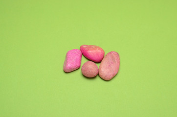 Obraz na płótnie Canvas pink pebbles on green background