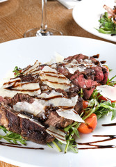 Traditional Italian main dish. Beef tagliata: tender beef rib eye, arugula, cherry tomatoes