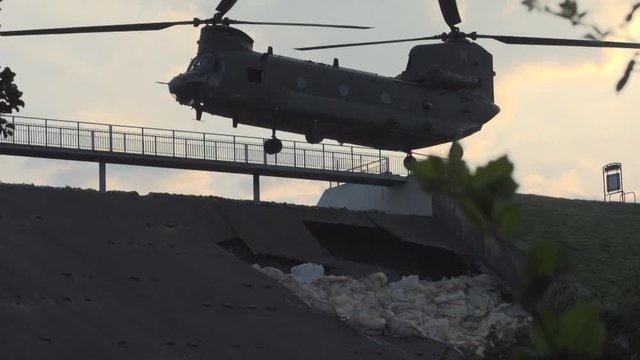 Chinook helicopter drops bags of aggregate in effort to prevent dam collapse
