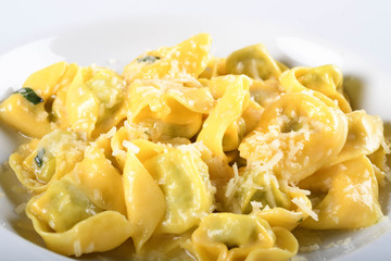 Tortellini with ricotta cheese and spinach, butter, sage sauce, grated parmesan. Parmigiano-Reggiano flakes