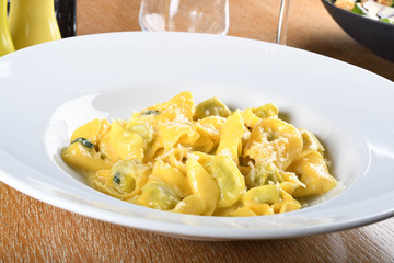 Tortellini with ricotta cheese and spinach, butter, sage sauce, grated parmesan. Parmigiano-Reggiano flakes