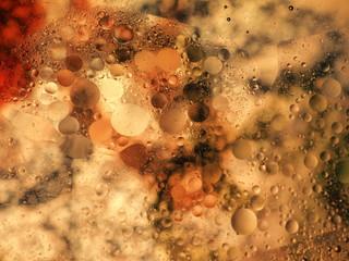 Mixing water and oil, beautiful colors. Orange light. Close-up. Abstract macro background. Water and oil bubbles. Abstract light illumination