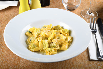 Tortellini with ricotta cheese and spinach, butter, sage sauce, grated parmesan. Parmigiano-Reggiano flakes