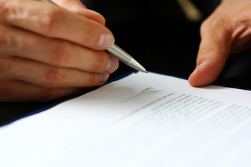 Male arm in suit and tie fill form clipped to pad