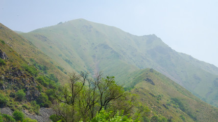 Naklejka premium mountain landscape road high mountains with haze and clouds