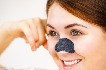 Woman applying pore strips on nose