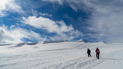 Image of a snow covered mountain plateau. Tourists walk and take pictures on a mountain plateau.