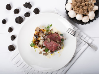 Truffle scented Beef Tenderloin, local truffle, gratin potatoes, sauteed wild mushrooms, cheese sauce