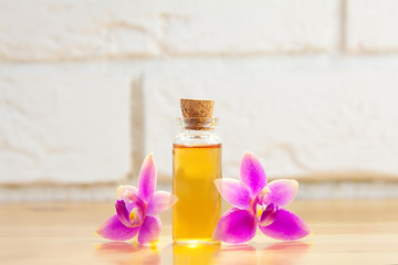 Essence of  orchid flowers on table in beautiful glass jar